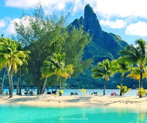 Palm-lined beach and turquoise lagoon beneath Mount Otemanu, Bora Bora