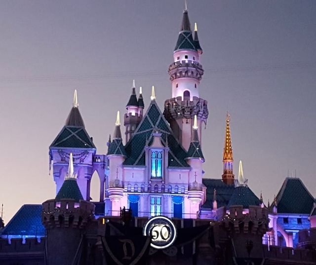 Sleeping Beauty Castle at Disneyland lit up at dusk