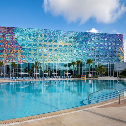 A pool in front of a colorful Universal Orlando resort hotel